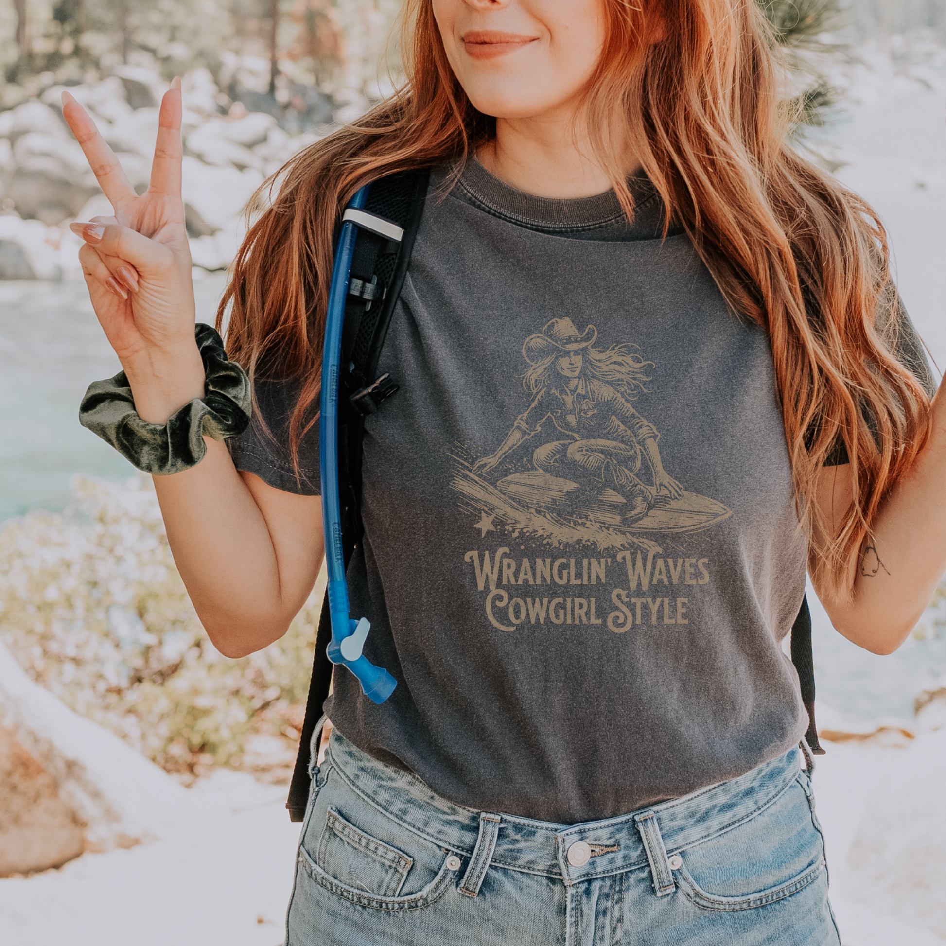 a woman wearing a gray t - shirt holding a peace sign