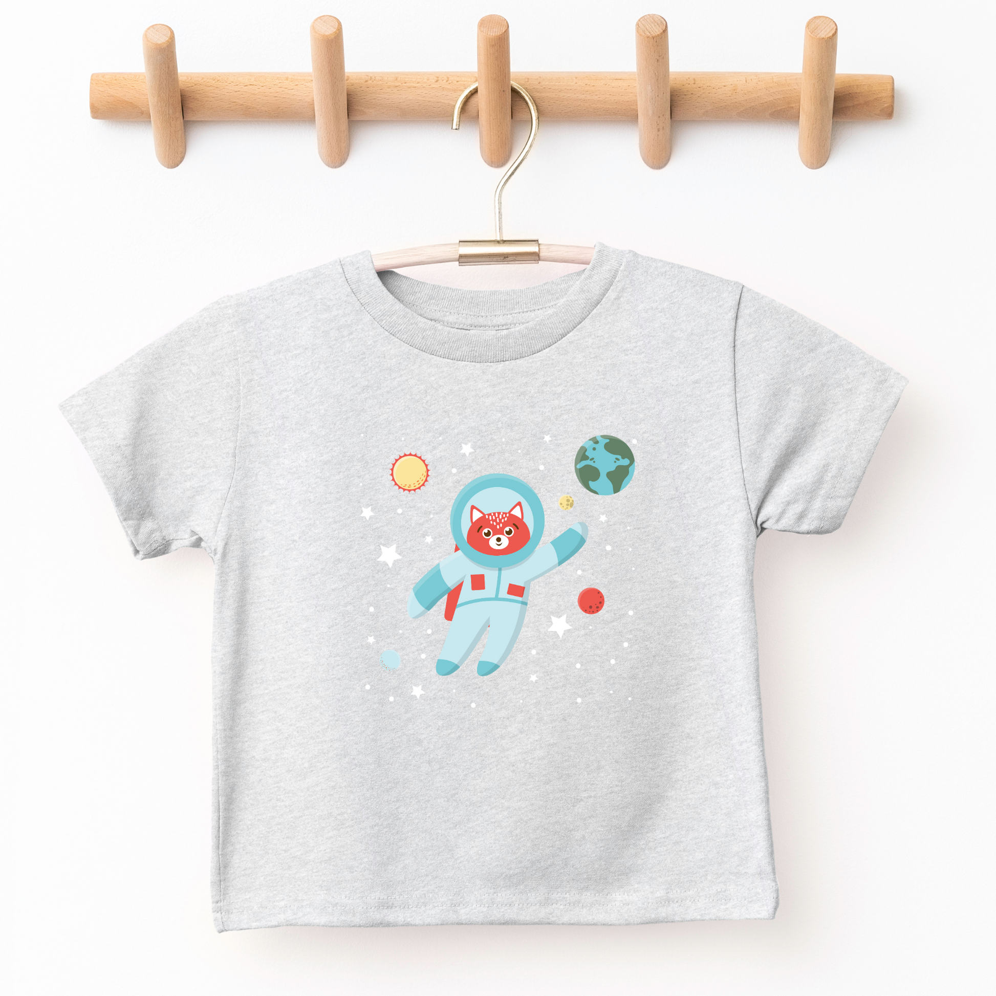 kid's graphic tee illustrated with cat in astronaut suit illutration. Around cat is image of Earth, sun and stars