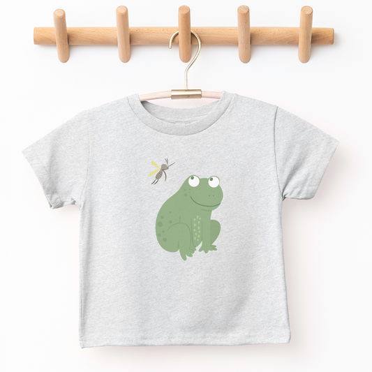 baby frog smiling up at dragonfly on kid's graphic tee